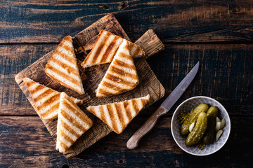 hot toasted sandwich panini with ham and cheese on wooden cutting board