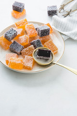 Assortment of colorful fruit jelly on white marble.
