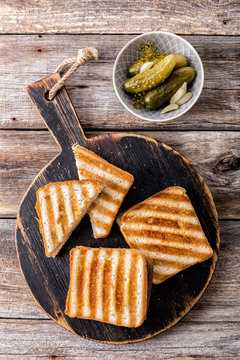 hot toasted sandwich panini with ham and cheese on wooden cutting board