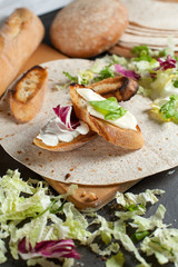sandwiches with fresh herbs, sour cream and cheese and bread on a dark background
