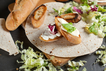 sandwiches with fresh herbs, sour cream and cheese and bread on a dark background