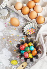 Colored easter eggs and baking molds on a light canvas background,place for text