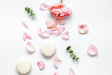 flat lay with petals and macaroons on white background top view