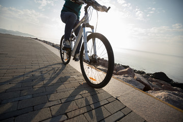 cyclist riding bike in the sunrise coast path
