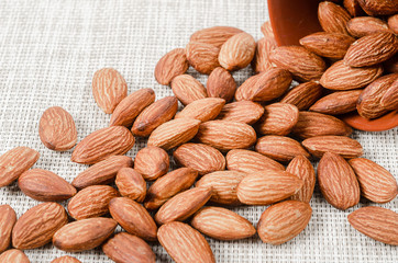 Almonds in bowl on sackcloth.