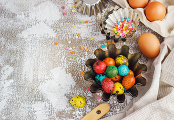 Colored easter eggs and baking molds on a light canvas background,place for text