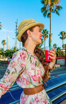 tourist woman on embankment with bright red beverage relaxing