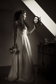 Young bride looking at mirror