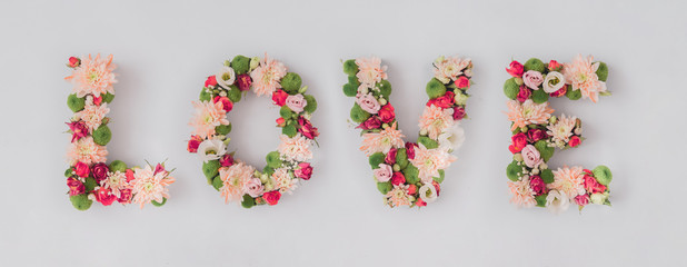 Word LOVE made of various flowers. Valentines day flat lay. Nature love concept.