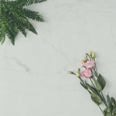 Creative natural composition made of flowers and leaves on marble background. Flat lay. Love concept.
