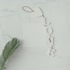 Creative natural composition made of leaves and decration on marble background. Flat lay. Love concept.