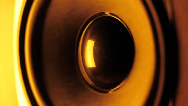 LoudSpeaker in Action. Thumping bass audio-speaker. Orange neon led light. Slow motion.