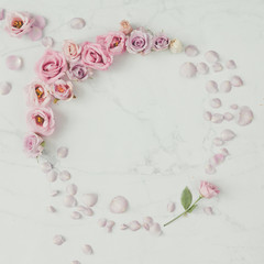 Creative round wreath frame made of rose flowers and petals. Flat lay composition. Nature love concept.