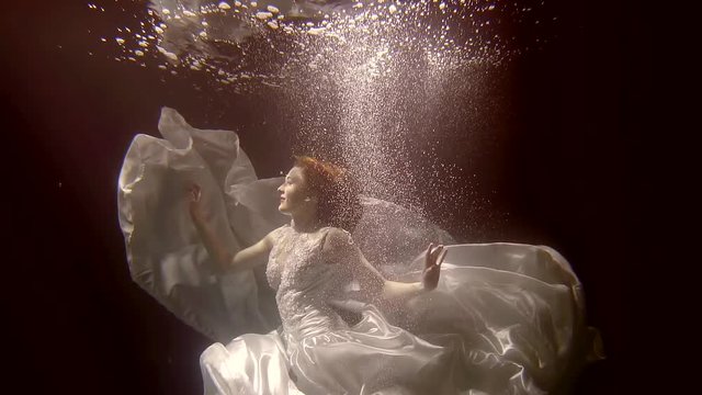 Very attractive woman falls into the water in her beautiful weddind dress.