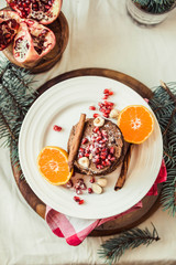 Chocolate banana pancakes with pomegranate and mandarin, winter vegan breakfast..New Year Christmas background. Top view.