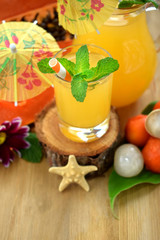 Yellow beverage decorated with straws and little cocktail umbrellas in glass vessels