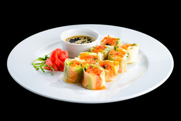 Fresh Vegetable Spring Rolls with soy sauce and ginger in a white plate, isolated on black background