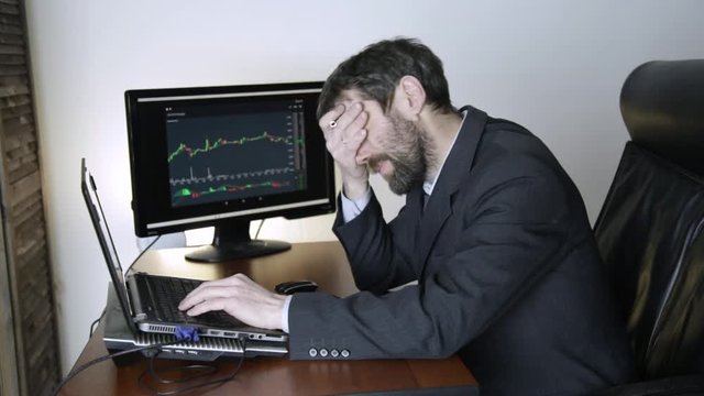 trader watching changes in the currency exchange chart, looking at laptop. Work on a stock exchange.