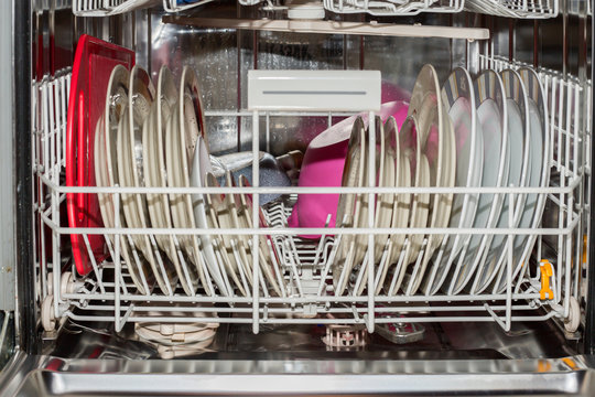 An open dishwasher with clean dishes