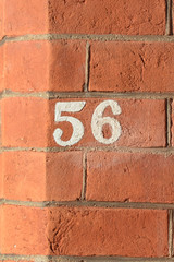 House number 56 sign painted on wall