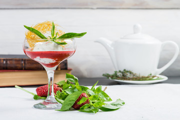 Fresh sweet strawberry smoothie with mint in a wine glass on light background