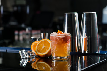 Fresh cocktail with orange and ice. Alcoholic, non-alcoholic drink-beverage at the bar counter in the night club.