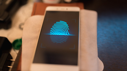 Smartphone fingerprint scan technology. Try to unlock mobile phone. Dark black background.