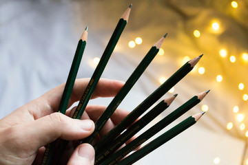 sketch artist with handful of pencils