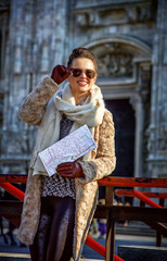 traveller woman in Milan, Italy with map looking into distance