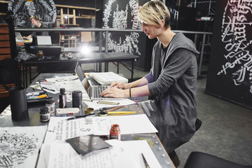Portrait of a master calligrapher. A tattoo artist makes a sketch while sitting at a table in the...