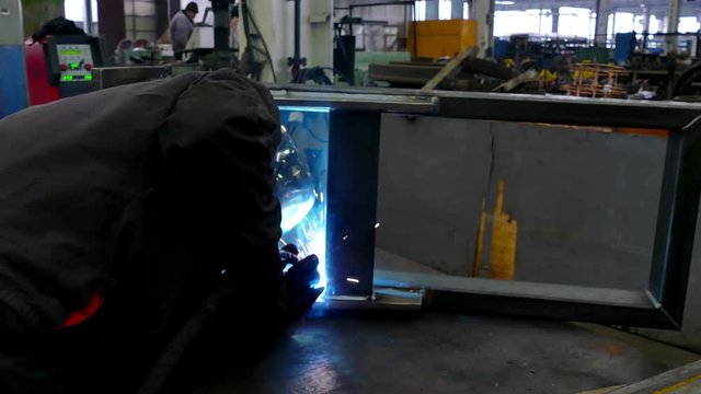 Blue Flame of the Welding Machine / Worker welder performs arc-welding process of metal structures