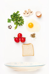 The falling ingredients of fried egg. Healthy breakfast ingredients.