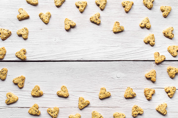 Homemade cookies with turmeric and flax seeds in the form of heart on white boards.