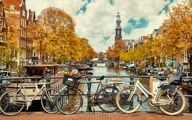 Deurstickers Amsterdam Fiets over kanaal Amsterdam stad. Pittoresk stadslandschap