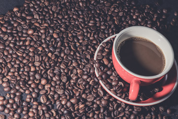 coffee in red cup and coffee beans are the background.