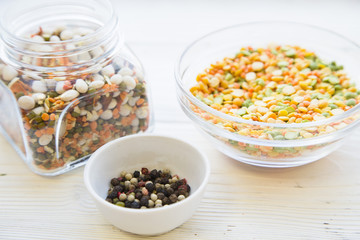 Preparing Healthy Food, Kitchen Concept. Cooking ingredients on awhite wooden table: bowls with colorful beans and pepper corns