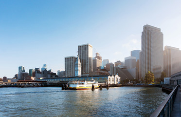 The Port of San Francisco at sunset with a boats near it. City skyline from the bay at the evening