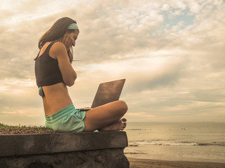 successful Digital Nomad girl with laptop on the beach