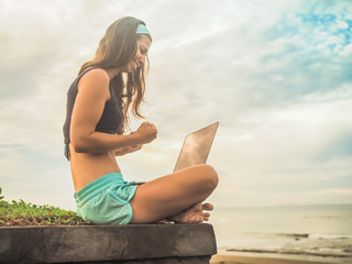 successful Digital Nomad girl with laptop on the beach