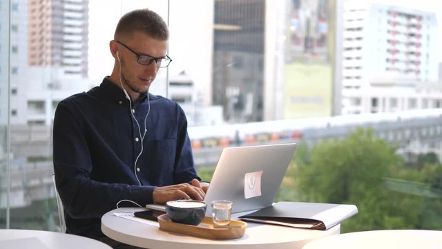 Handsome Hipster Man Working On Laptop On Coffee Break. 4K.