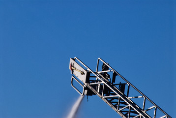 Fire Department Ladder Spraying Water onto a Fire