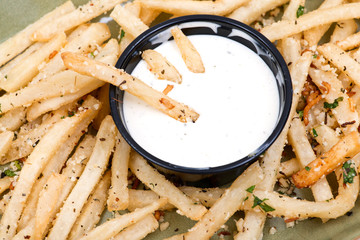 GARLIC PARMESAN FRIES with ranch dipping sauce on green ceramic plate