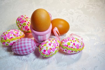 Easter chicken egg in a cup and colorful Easter eggs on a grey background - Easter composition.Easter Tradition - Selective focus

