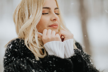 Blonde woman outside in snow winter coat