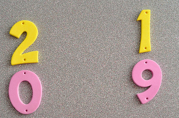 2019 in pink and yellow numbers on a silver background