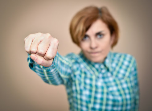 Angry woman threatening with her fist. Selective focus.