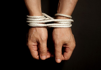 Male hands bound with rope.