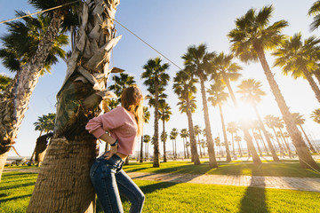 young sexy woman on a background of palms and sunset