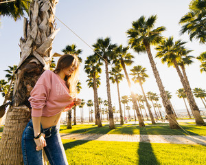 young sexy smiling woman on a background of palm trees and sunset
