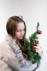 girl with a small Christmas tree hugs